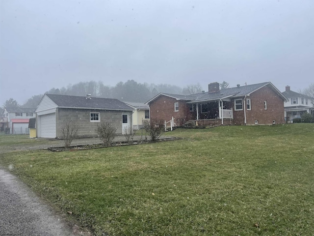 rear view of property with a garage and a yard