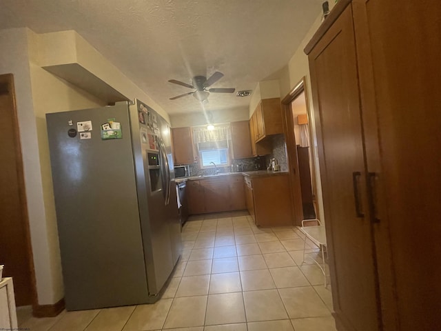 kitchen with appliances with stainless steel finishes, sink, backsplash, light tile patterned floors, and ceiling fan