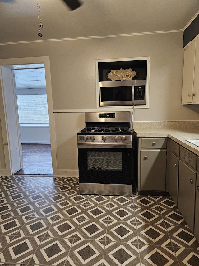 kitchen featuring white cabinetry, ornamental molding, and stainless steel appliances