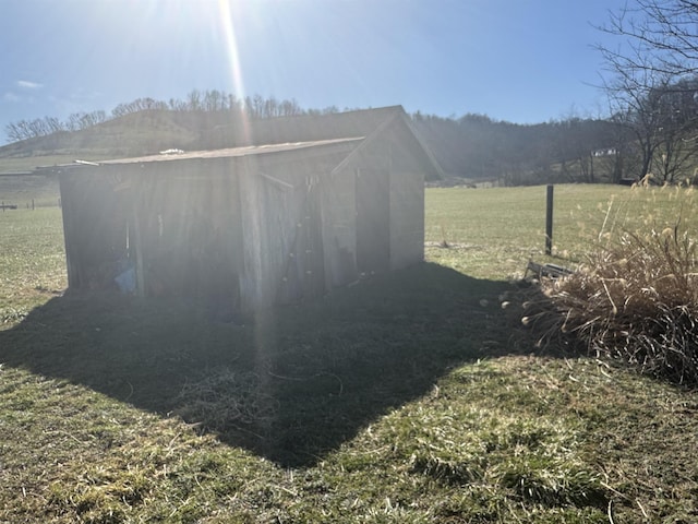 view of outbuilding with a rural view and a lawn