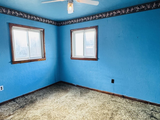 carpeted empty room featuring ceiling fan