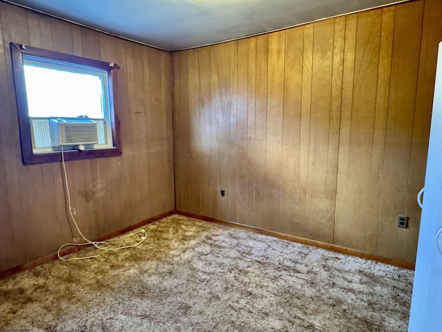 carpeted spare room featuring wooden walls