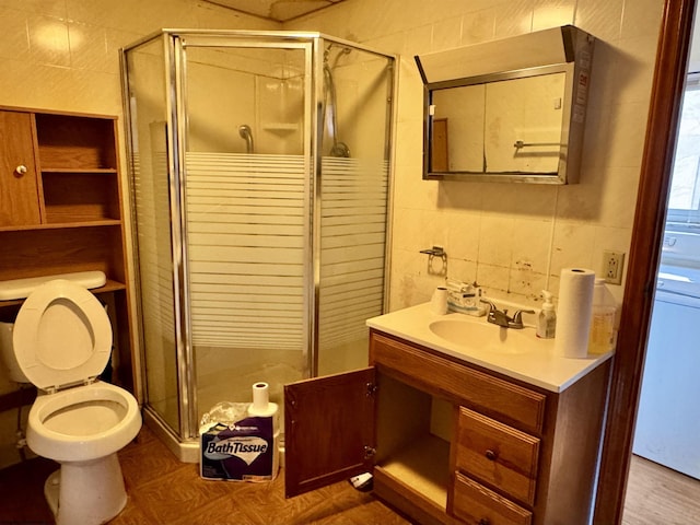 bathroom with toilet, an enclosed shower, tasteful backsplash, tile walls, and vanity