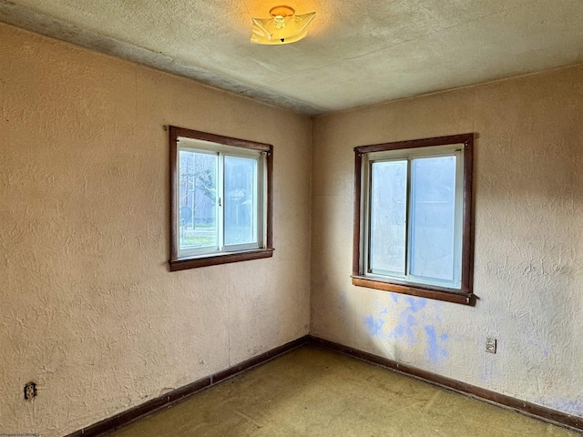 unfurnished room featuring a textured ceiling and carpet flooring