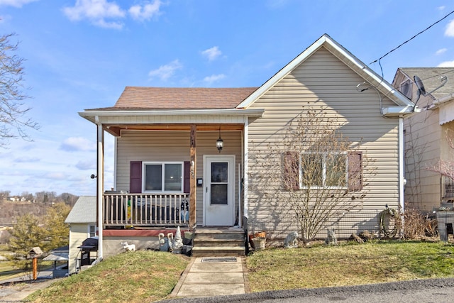 bungalow featuring a front yard and covered porch