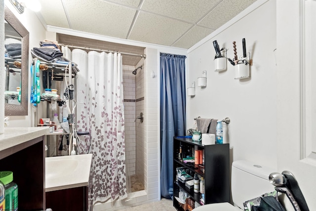 bathroom featuring a paneled ceiling, vanity, toilet, and curtained shower