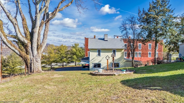 rear view of house featuring a lawn