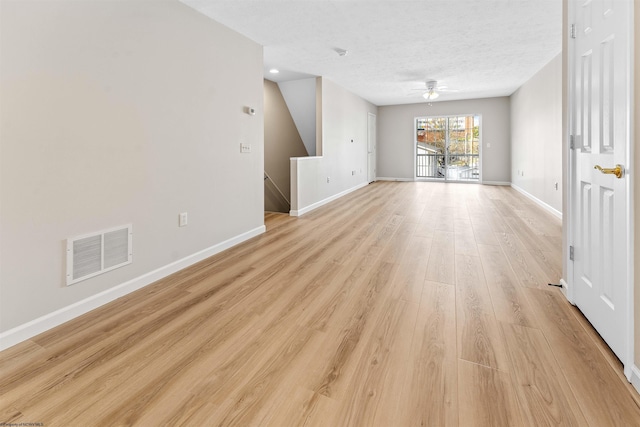 unfurnished living room featuring ceiling fan, light hardwood / wood-style flooring, and a textured ceiling