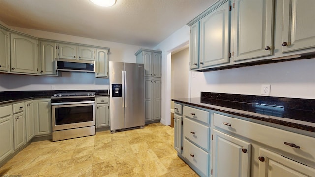 kitchen featuring appliances with stainless steel finishes and dark stone counters