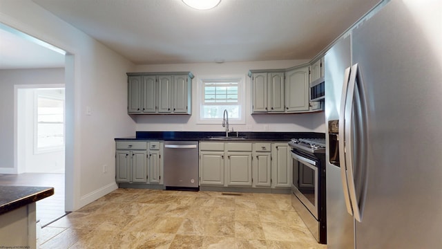 kitchen with stainless steel appliances, sink, and gray cabinets