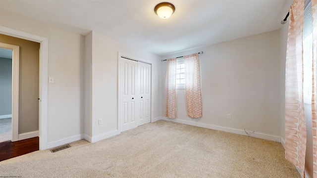 unfurnished bedroom with light carpet and a closet