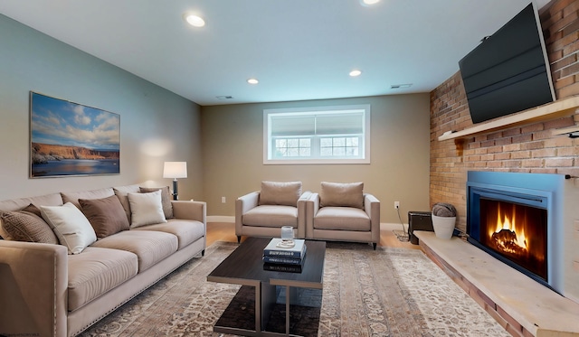 living room with hardwood / wood-style floors and a brick fireplace