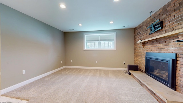 unfurnished living room featuring a brick fireplace and light colored carpet