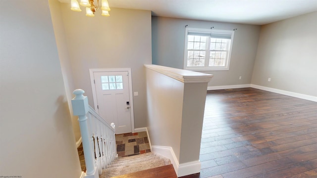 foyer entrance featuring an inviting chandelier and dark wood-type flooring