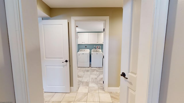 clothes washing area featuring cabinets and washer and dryer