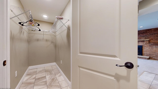 spacious closet featuring a fireplace