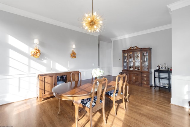 dining space featuring ornamental molding, a chandelier, and wood-type flooring