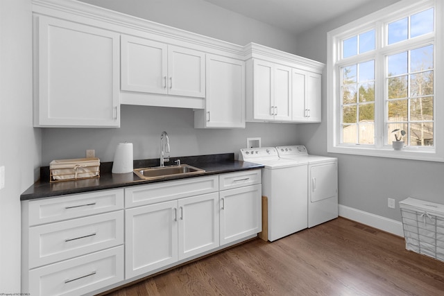 washroom with cabinets, sink, washing machine and clothes dryer, and light wood-type flooring