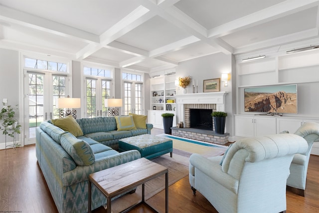 living room featuring french doors, coffered ceiling, built in features, beamed ceiling, and a fireplace