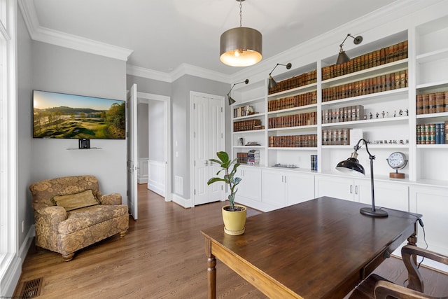 home office featuring wood-type flooring, built in features, and crown molding