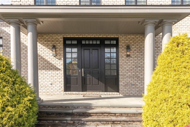 view of exterior entry featuring covered porch