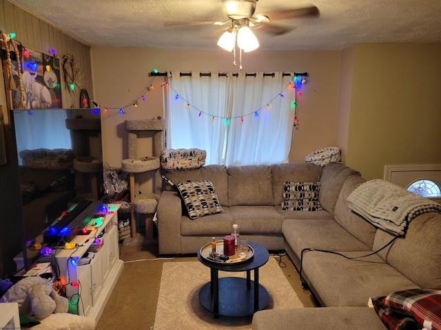 carpeted living room featuring ceiling fan and a textured ceiling