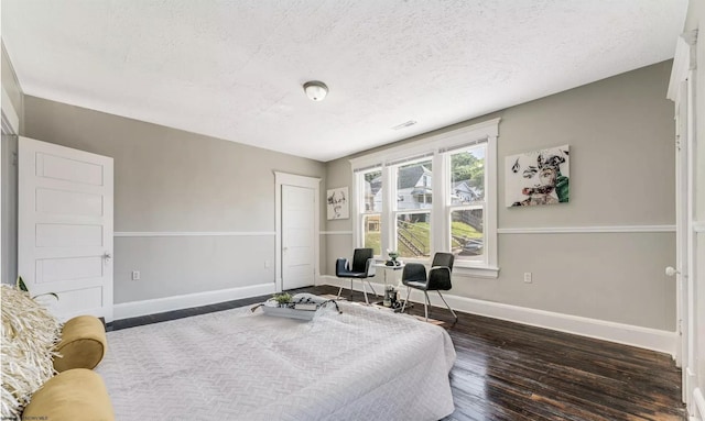 bedroom featuring dark hardwood / wood-style floors and a textured ceiling