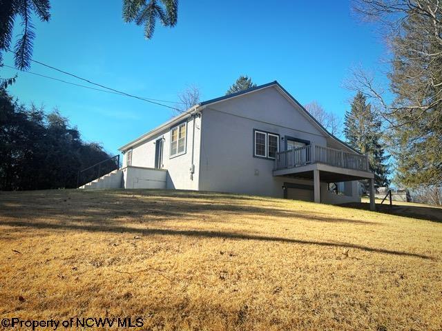 view of home's exterior with a wooden deck and a lawn