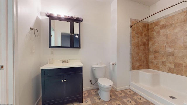 bathroom featuring tiled shower, vanity, and toilet