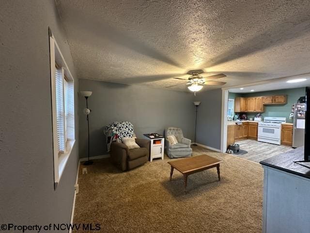 living room featuring light colored carpet, a textured ceiling, and ceiling fan