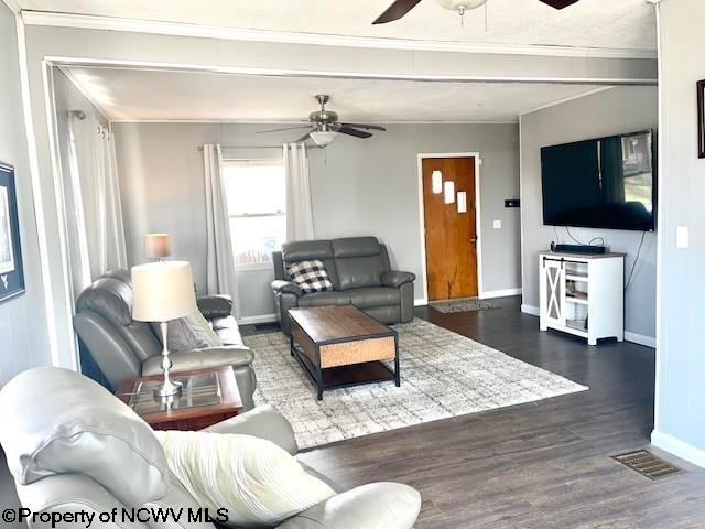 living room with ceiling fan, crown molding, and dark hardwood / wood-style flooring