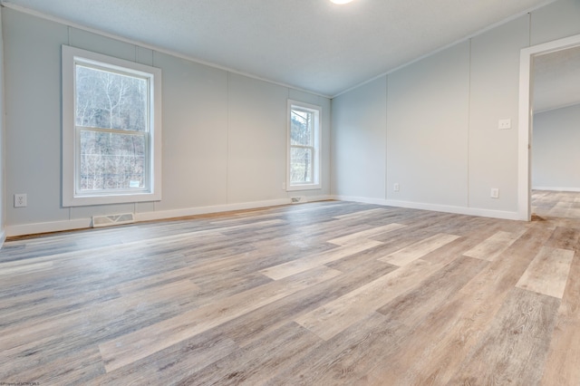 spare room with crown molding and light hardwood / wood-style flooring