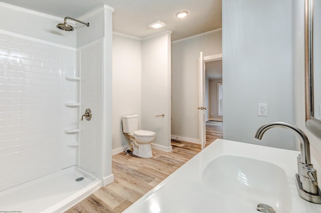 bathroom with toilet, sink, a shower, wood-type flooring, and ornamental molding