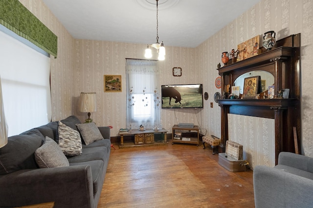 living room featuring hardwood / wood-style floors, an inviting chandelier, and a fireplace