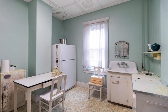 kitchen with white refrigerator and a drop ceiling