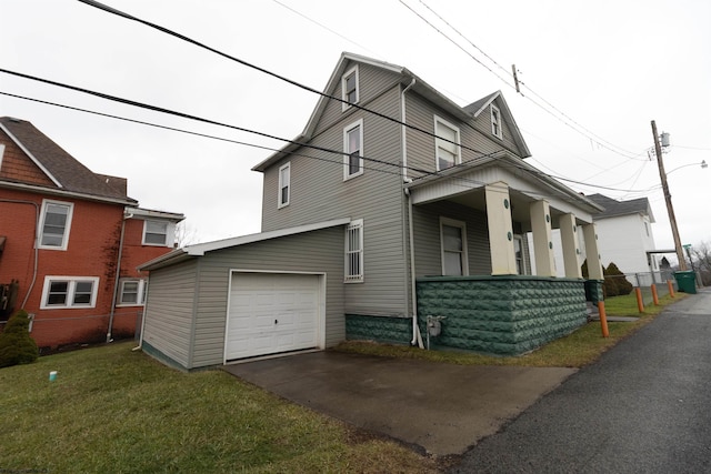 view of side of home with a garage, a yard, and covered porch