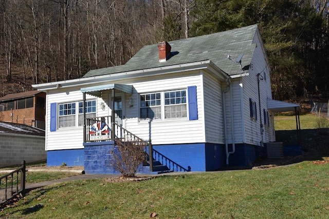 view of front of house featuring a chimney and a front lawn