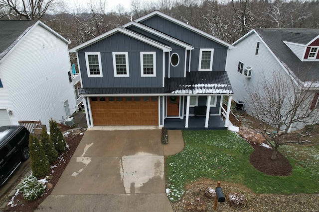 view of front of home featuring central air condition unit, covered porch, a front lawn, and a garage