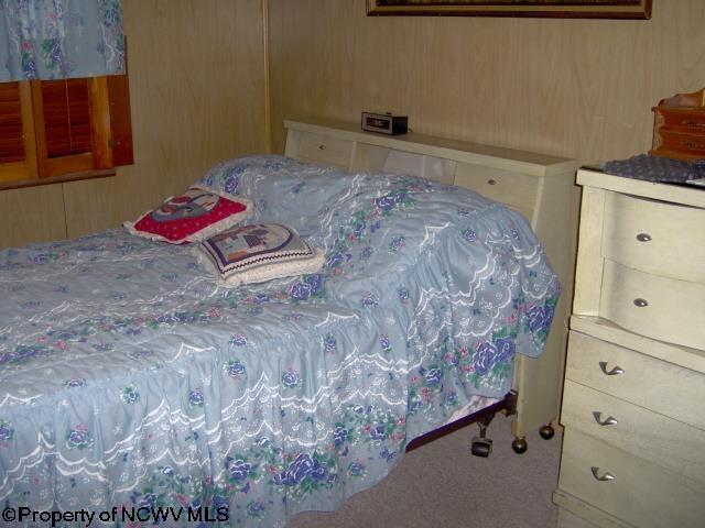 carpeted bedroom with wooden walls