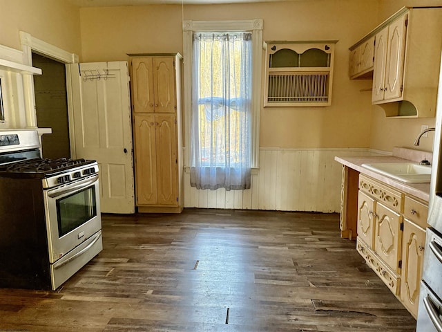 kitchen featuring stainless steel range with gas cooktop, dark wood-type flooring, sink, and light brown cabinetry