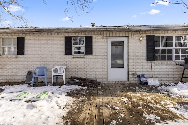 snow covered property with a deck