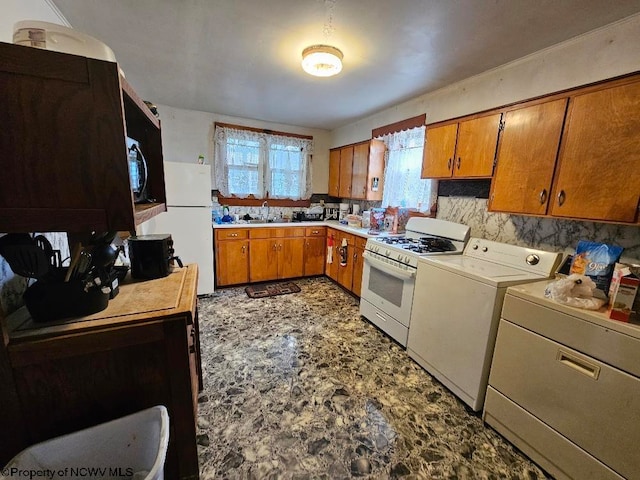 kitchen featuring sink, washing machine and clothes dryer, white appliances, and backsplash