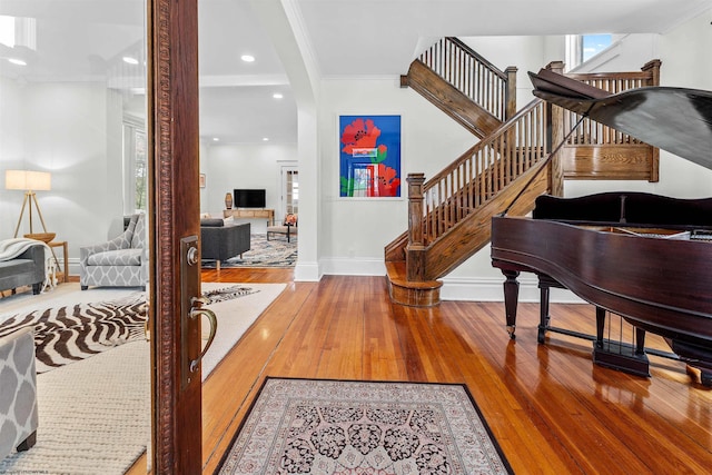 entrance foyer featuring baseboards, wood finished floors, ornamental molding, recessed lighting, and stairway