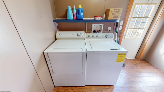 clothes washing area featuring washer and dryer, laundry area, and wood finished floors