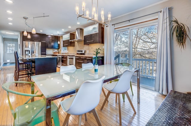 dining space with recessed lighting, plenty of natural light, light wood-style flooring, and crown molding