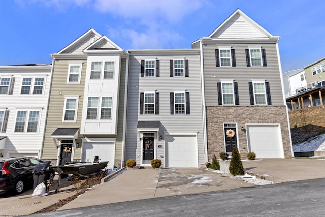 multi unit property featuring a garage and driveway