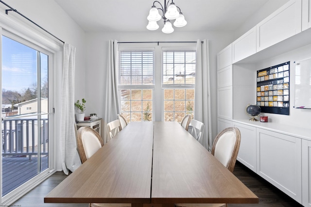 dining space with dark wood-type flooring and a notable chandelier