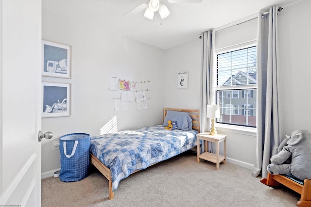 carpeted bedroom with a ceiling fan and baseboards