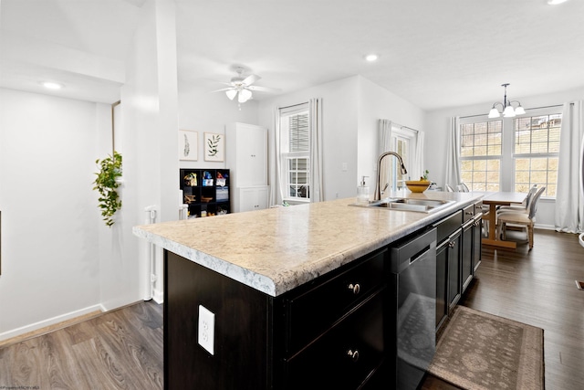 kitchen with pendant lighting, light countertops, stainless steel dishwasher, a sink, and an island with sink