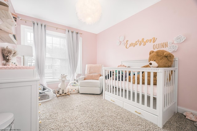 carpeted bedroom with a nursery area, multiple windows, and baseboards